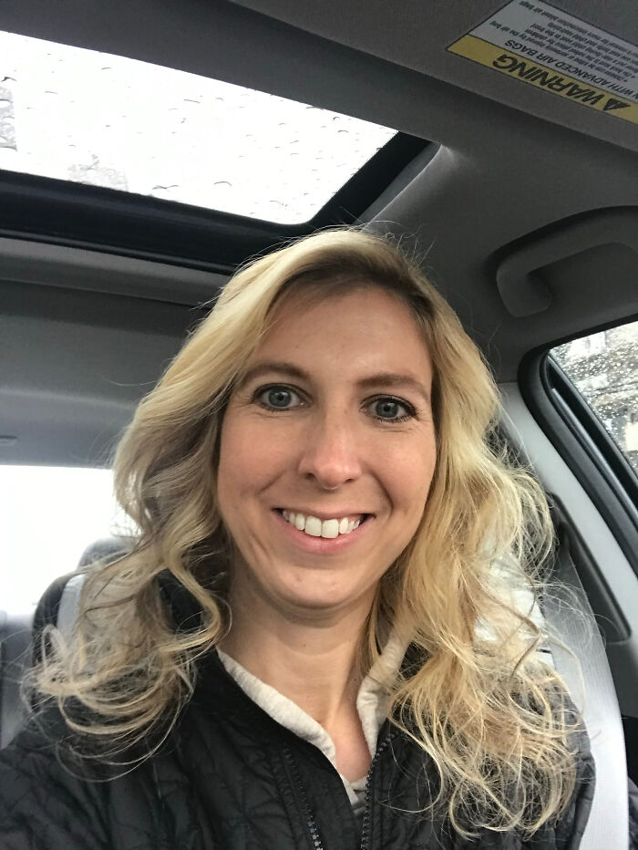 A woman with blonde hair smiling in a car, an example of surprising facts that don't match people's looks.