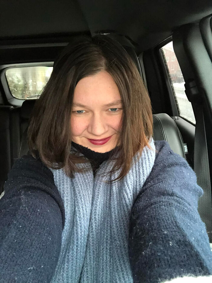 A woman with brown hair and a scarf in a car, illustrating surprising facts that dont match people's looks.
