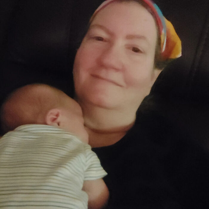 A woman holding a baby, a surprising fact that doesn't match her looks at all, smiling gently.