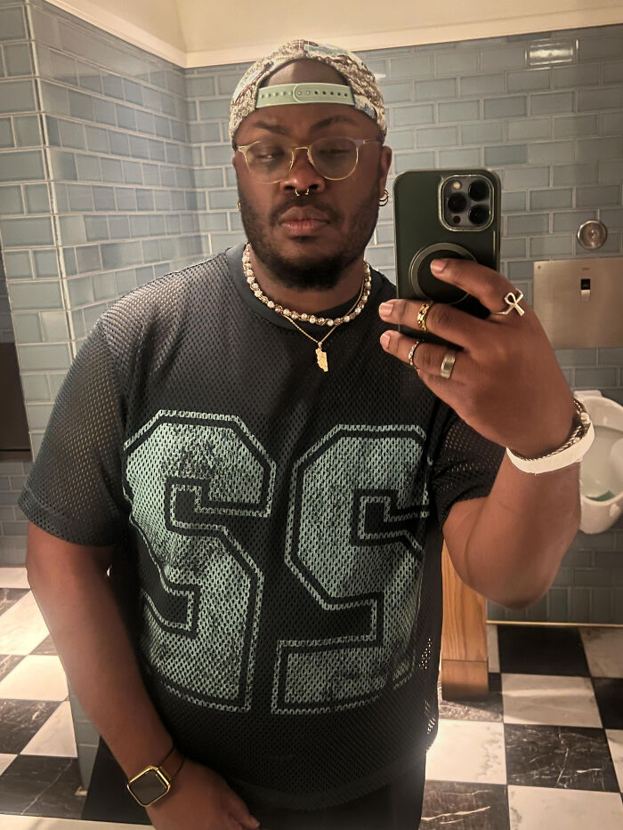 A man in a jersey and a patterned cap taking a mirror selfie, a surprising fact that doesn't match his looks at all.