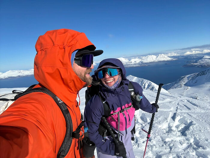 A couple in ski gear takes a selfie on a snowy mountain, showcasing surprising facts about people's looks.