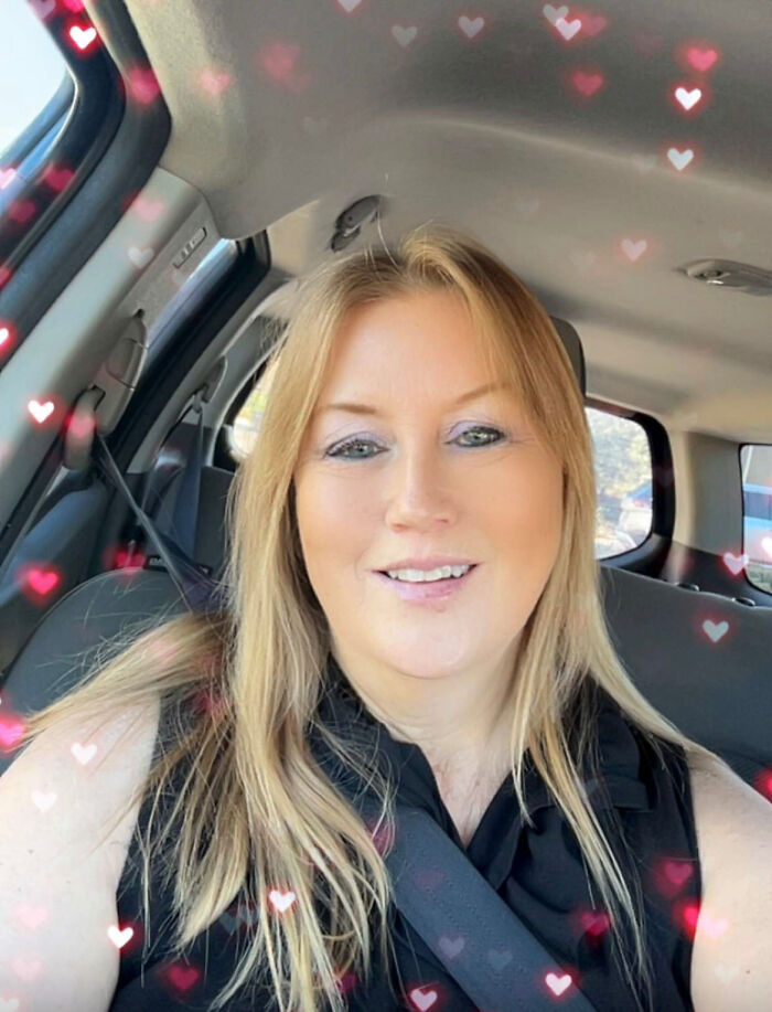 A smiling blonde woman in a car with heart-shaped light effects. Surprising facts about people's looks.