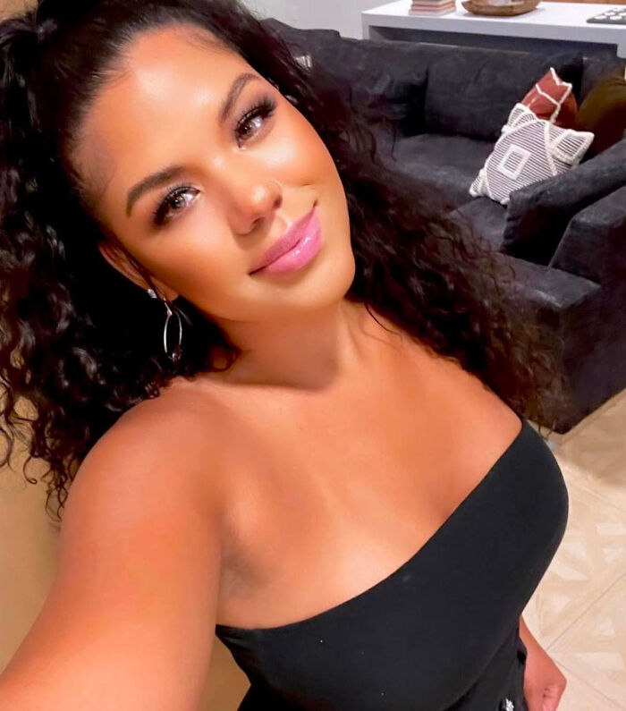 A woman with curly hair and a black top, defying people's looks and common perceptions.