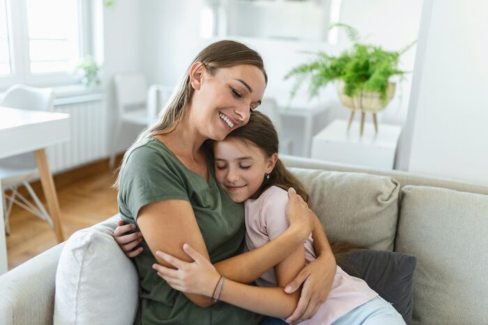 A mom hugging her daughter on a couch, representing the change in dads views of women.