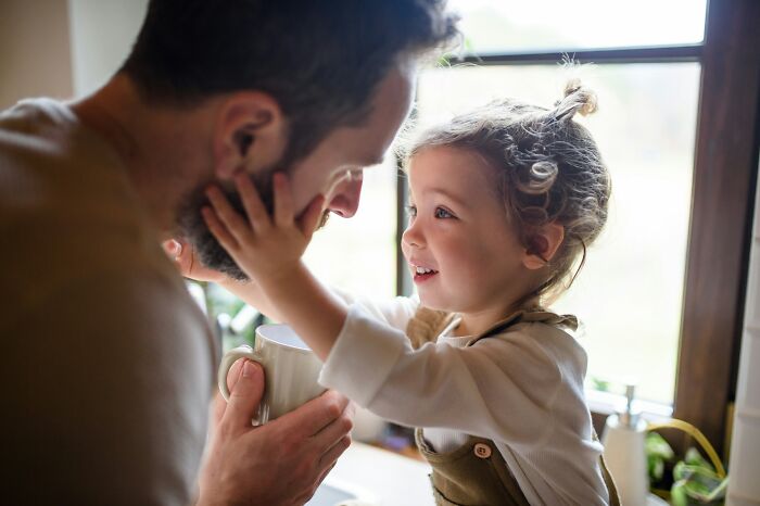 A smiling daughter touching her dad's face, demonstrating how dads views of women changed.