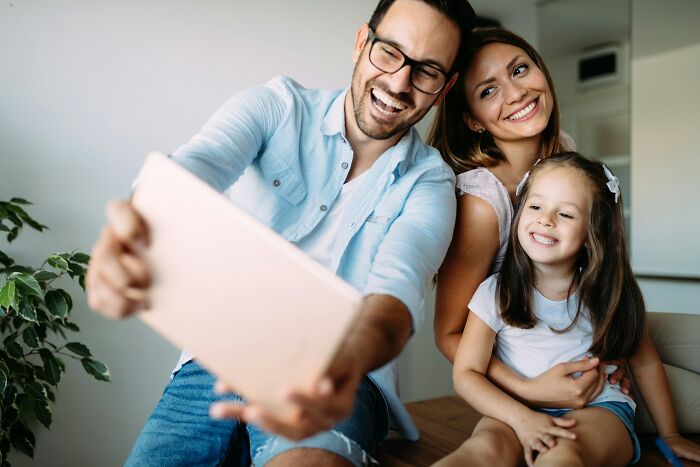 A happy family, a dad, mom, and daughter taking a selfie. Dads with daughters understand women differently.