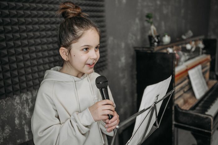 A daughter singing into a microphone. Dads' understanding of women changed.