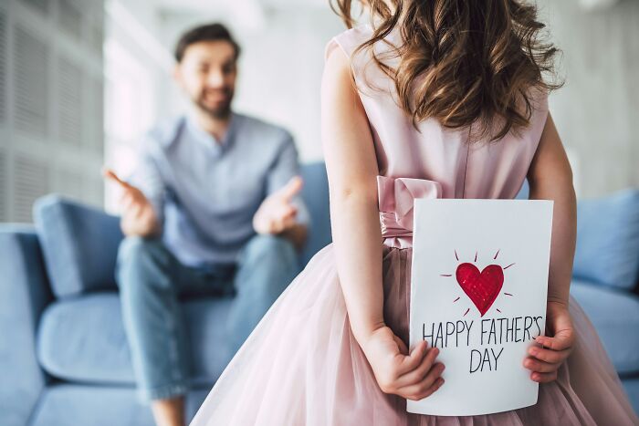 Daughter holding a Fathers Day card for her dad, highlighting the bond and changing views on women.
