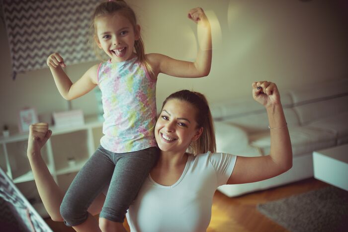 Mother and daughter flexing muscles, symbolizing the change in dads view and understanding of women.