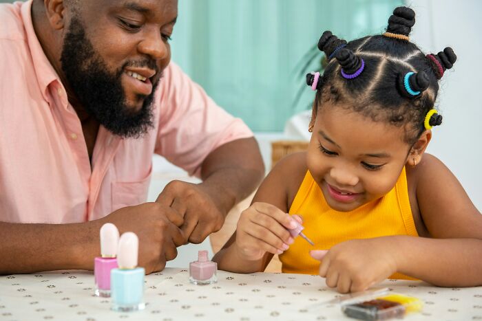 A dad and daughter painting nails together, highlighting how dads views of women changed.