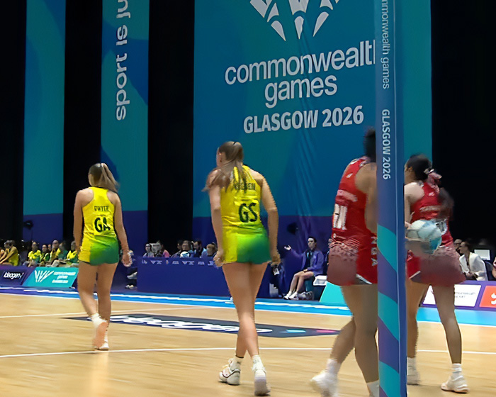 Back view of female athletes in unusual uniforms on court, showing tight fit and potential uniform issues.