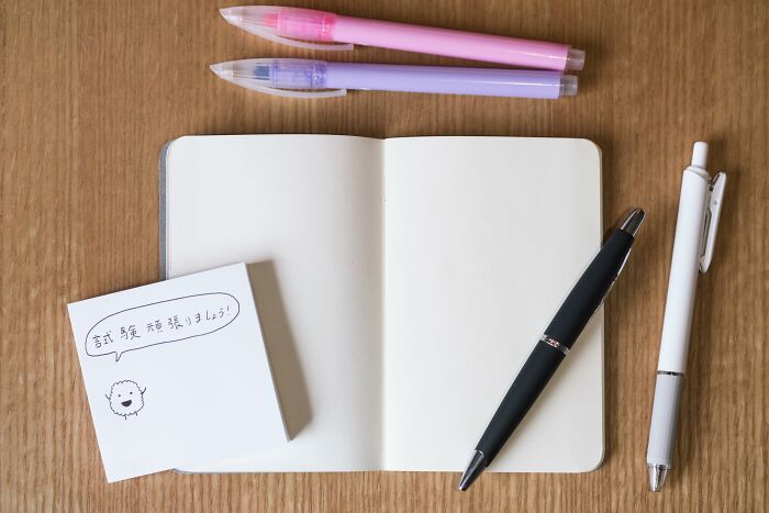 An open notebook with pens and a sticky note, showcasing creative industries that make millions.