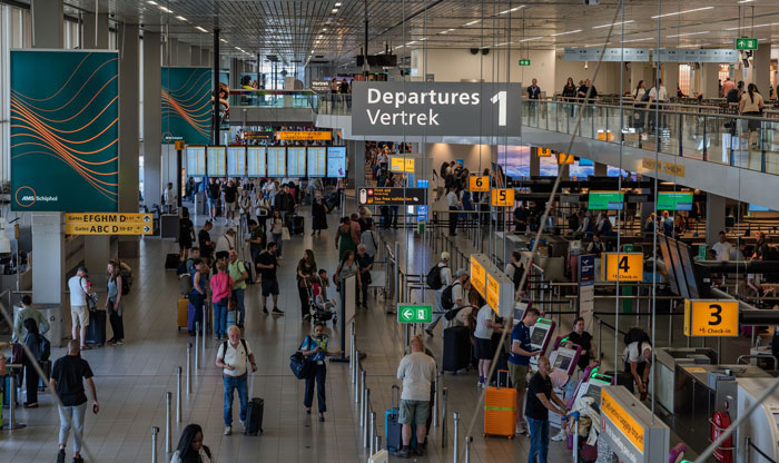 Airport security gate with a sign that says Departures in English and Dutch as travelers pass through to board their flights. Airport security gate with a sign that says Departures in English and Dutch as travelers pass through to board their flights.