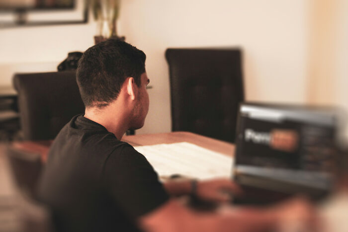 A man works on a laptop, focused on his tasks. Stories of people got fired from jobs due to poor performance.