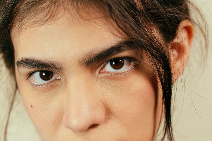 A close-up of a woman's intense eyes, conveying a look of exasperation, one of the many mansplaining examples.