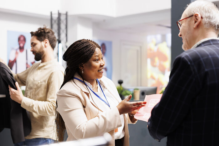 Smiling woman discussing packaging, one of the unpopular industries that make millions, with a male client.
