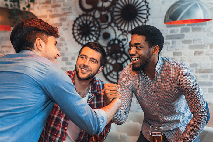 Three friends share a laugh, with one man making a plea, showing how connection can alleviate the pain of a lonely man. Three friends share a laugh, with one man making a plea, showing how connection can alleviate the pain of a lonely man.