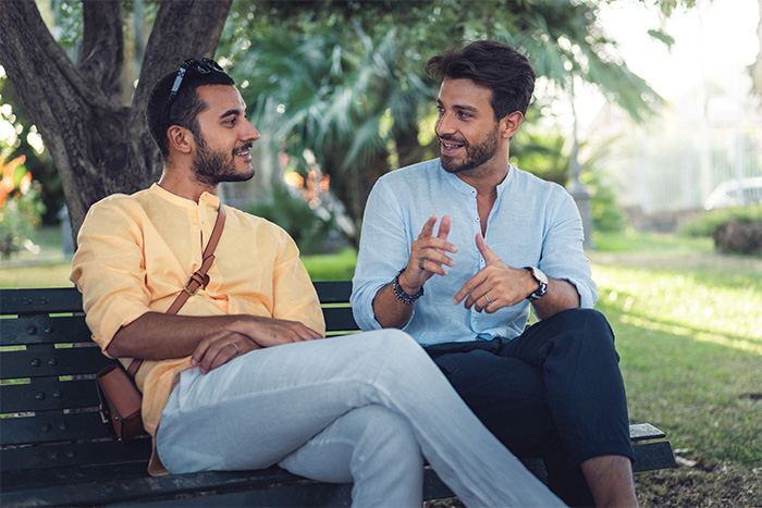 Two lonely men sitting on a park bench, engaging in a heartfelt conversation. Two lonely men sitting on a park bench, engaging in a heartfelt conversation.