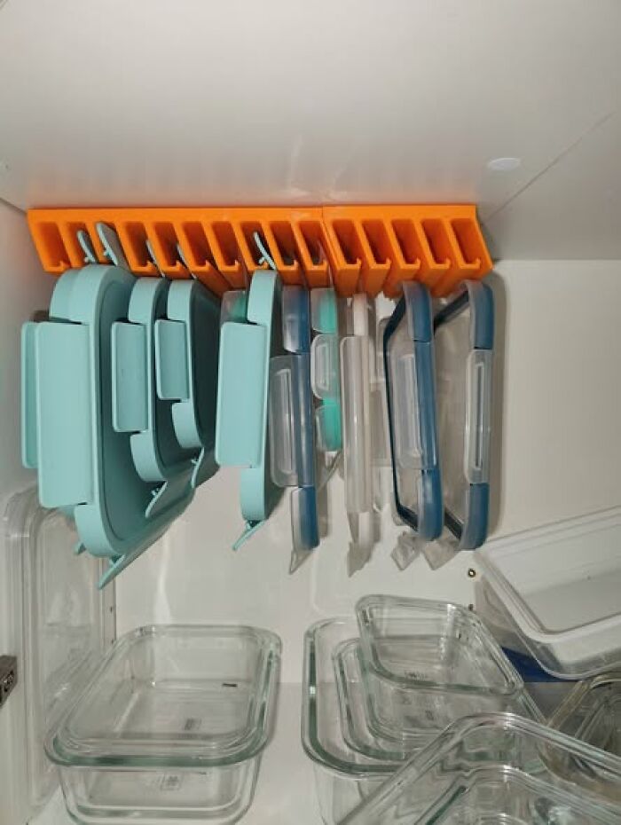 An orange 3D printer creation holds multiple food storage containers, a functional solution for kitchen organization.