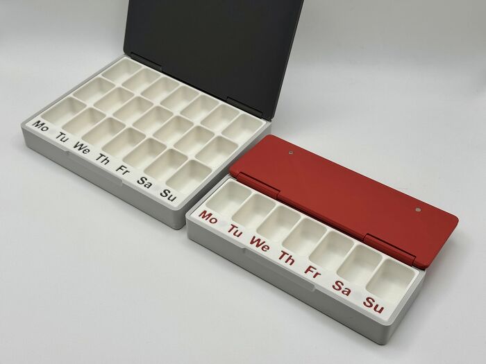 Two 3D printed pill organizers, one large and one small, with weekly labels, illustrating functional 3D printer items.