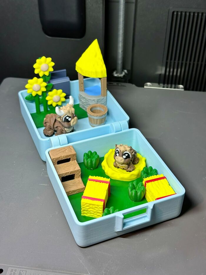 A charming miniature farm diorama, featuring tiny cows, a well, and sunflowers, all 3D printed for creative play.