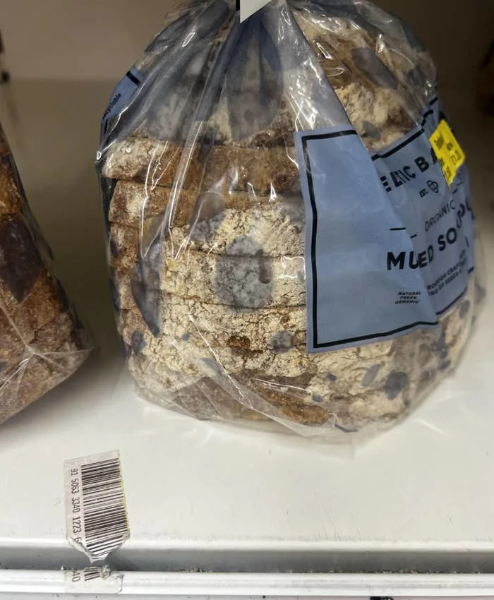 A bag of bread with a severe mold design fail, clearly past its prime and unappealing.