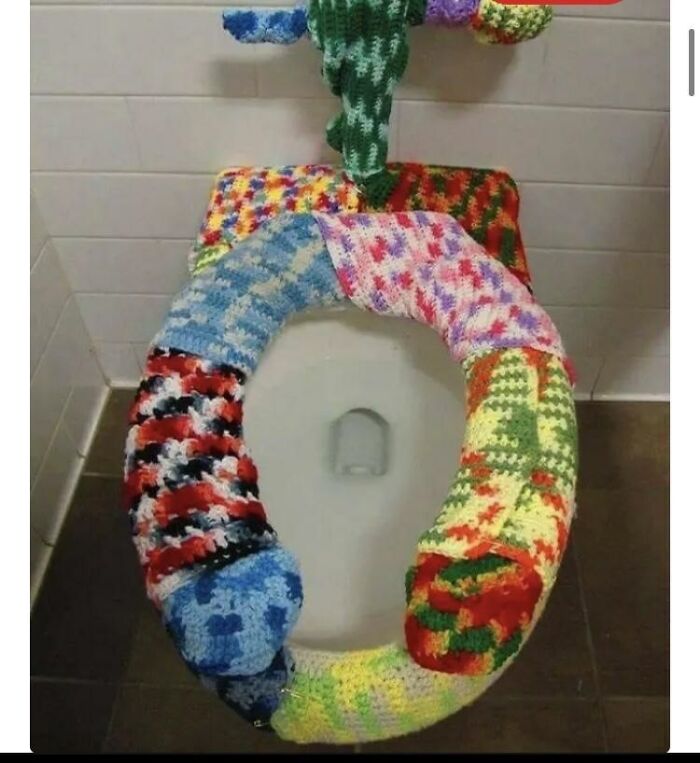 Terribly designed bathroom featuring a toilet with a colorful, crocheted cover, making it a unique bathroom fixture.