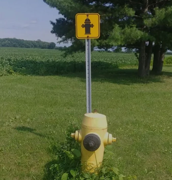 A hilariously failed sign with a fire hydrant icon above an actual fire hydrant.