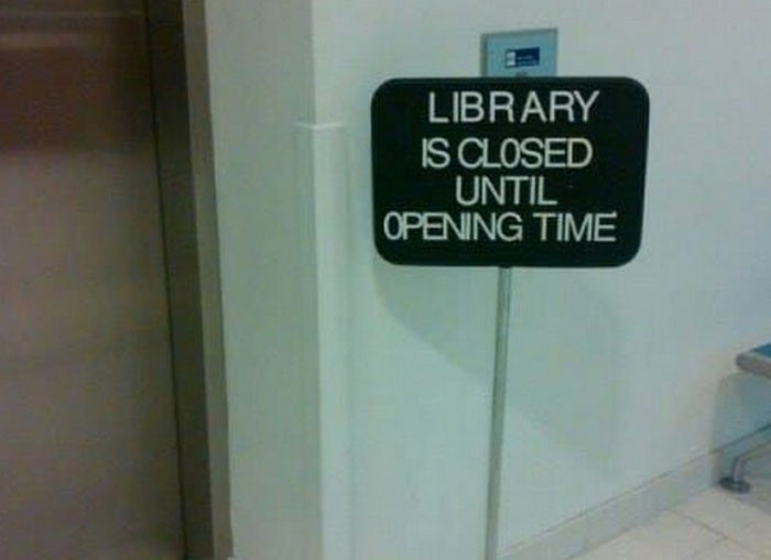 A sign on a library door reads Library Is Closed Until Opening Time, a clear instance of a hilariously failed sign.