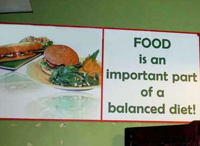 A hilariously failed sign states food is an important part of a balanced diet, with a picture of a burger and fries.