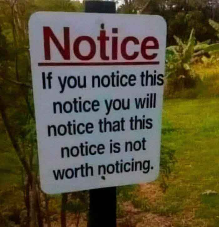 A hilariously failed notice sign in a green field, with repetitive text about noticing, failing to be worth noticing.