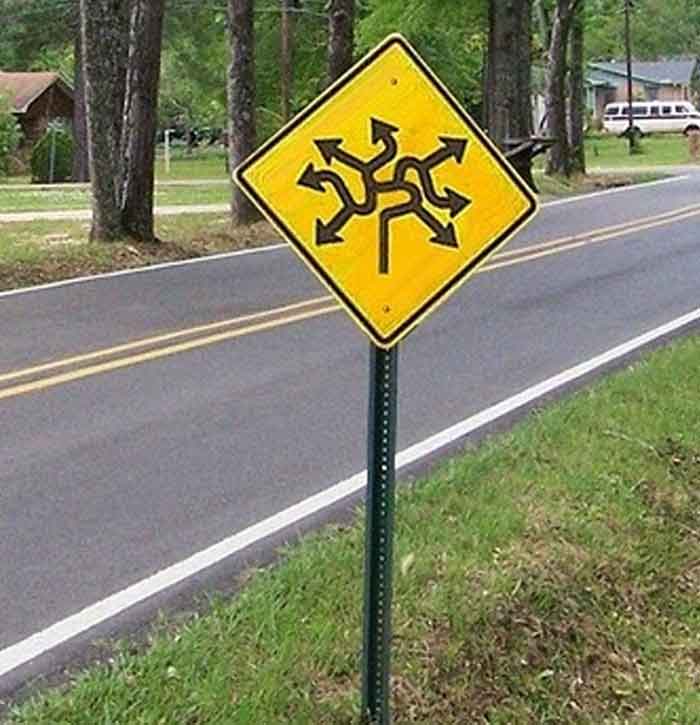 A hilariously failed road sign with many arrows pointing in all directions, failing to give clear guidance.