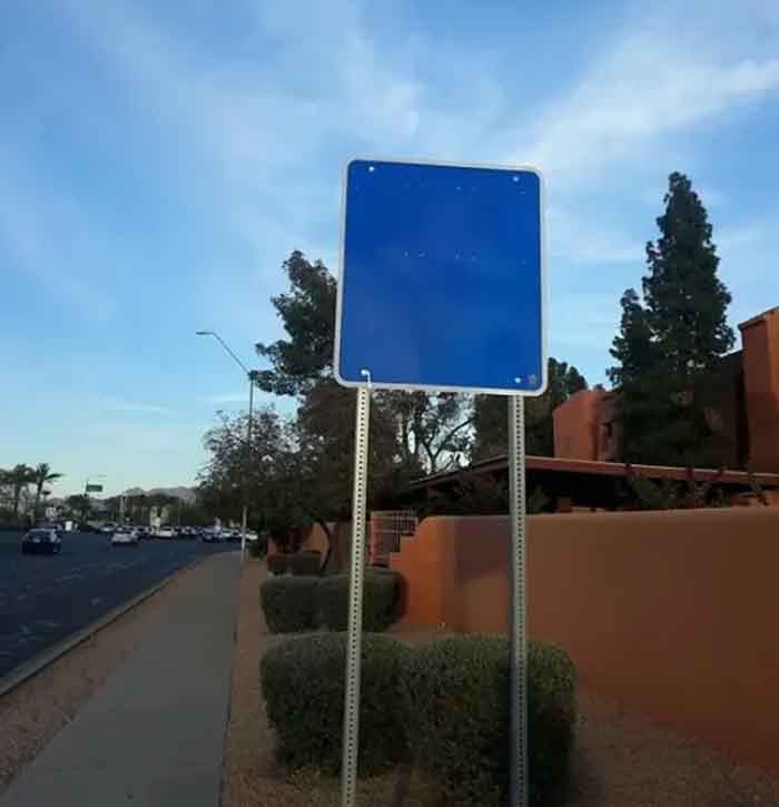 A hilariously failed blank blue sign by a road, failing to convey any message.