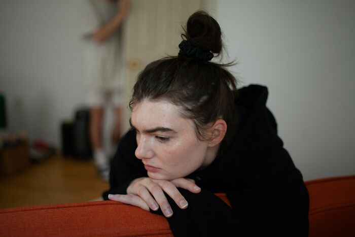 A young woman with a bun looks thoughtful, revealing subtle signs someone isn't as nice as they pretend to be.