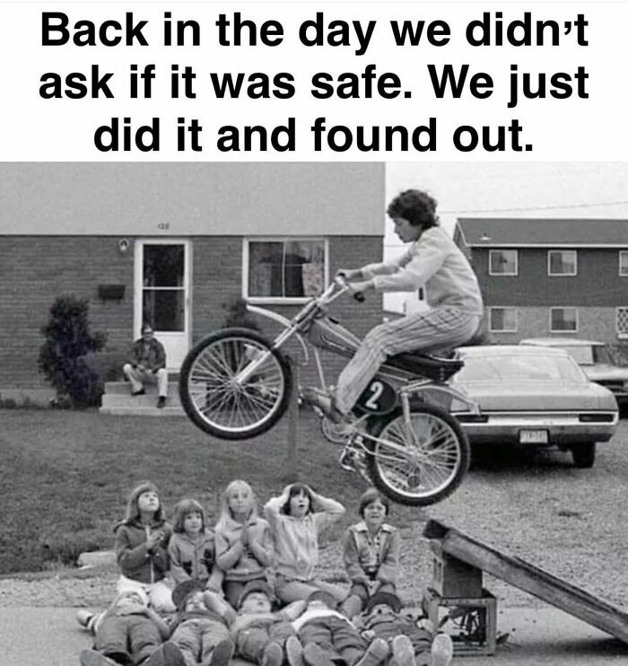 A black and white Gen X meme: a person on a motorcycle jumping over kids lying on the ground, showcasing 80s freedom.