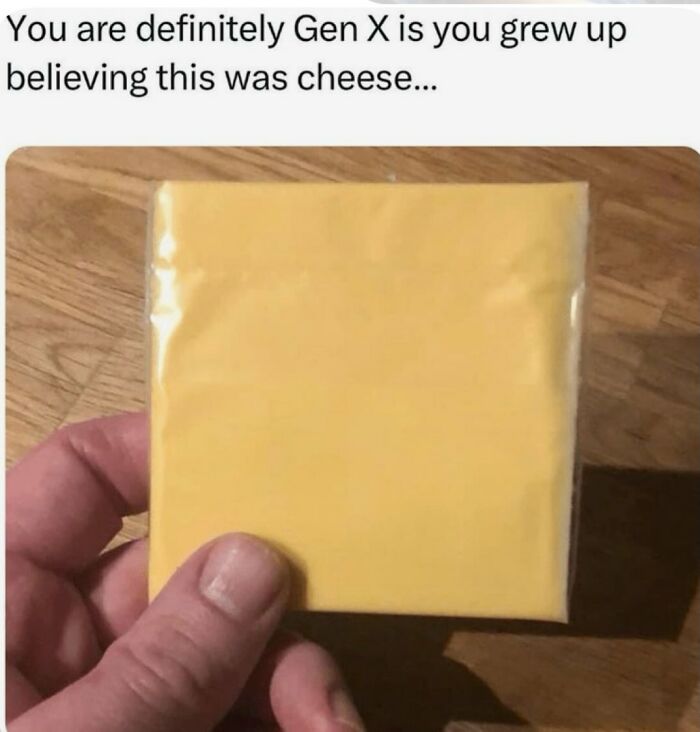 A hand holding a plastic-wrapped slice of cheese. This Gen X meme recalls childhood memories of believing processed cheese was real cheese.