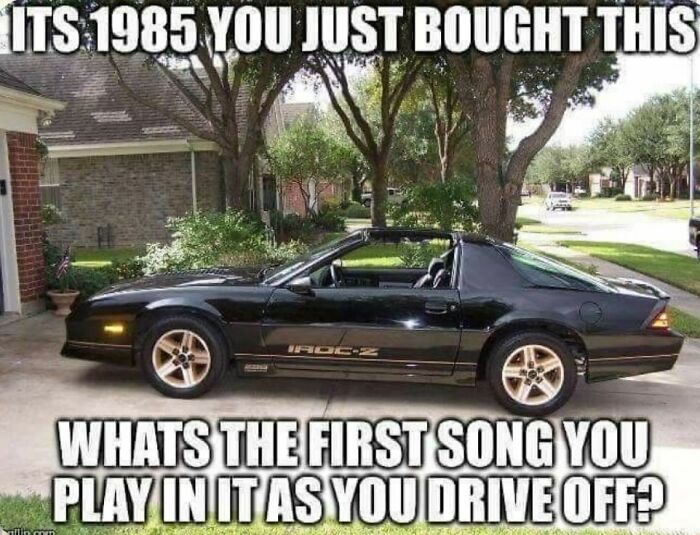 A black 1985 IROC-Z Camaro parked in a driveway, evoking Gen X memories.