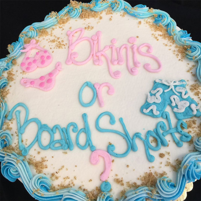 A Gender Reveal cake with 'Bikinis or Board Shorts' in pink and blue icing. People are judging the parents.