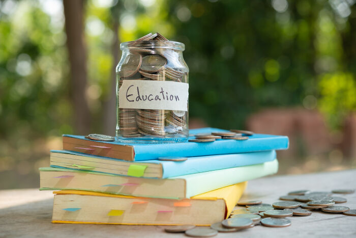 A jar of coins labeled Education on a stack of books, illustrating common things that are far worse than we realize.