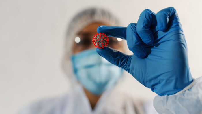 A scientist holding a model of a virus, representing common things that may turn out to be worse than we realize.