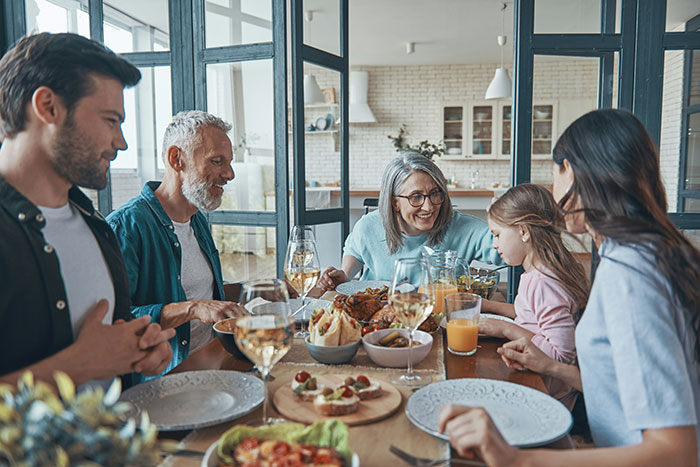 Sebuah keluarga multi-generasi dengan gembira duduk mengelilingi meja makan, menunjukkan kebiasaan yang sulit di meja makan. Sebuah keluarga multi-generasi dengan gembira duduk mengelilingi meja makan, menunjukkan kebiasaan yang sulit di meja makan.