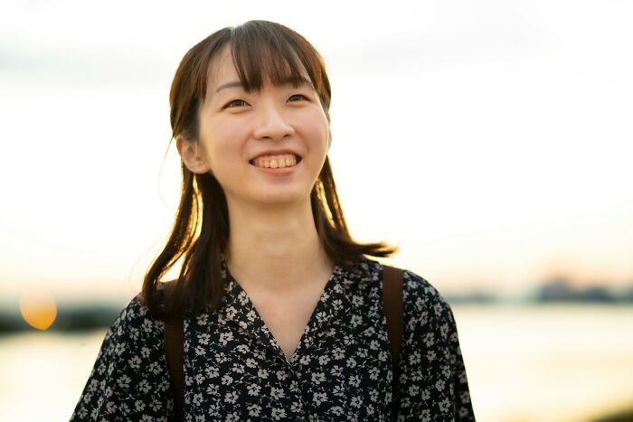 A smiling woman with international partners experiencing culture shocks.