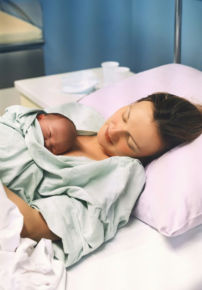 A mother and her newborn baby sleep together in a hospital bed, highlighting potential medical mistakes.
