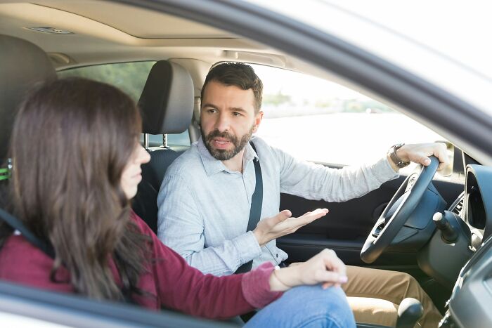 A man talking to a woman in a car, gesturing with his hand, showing cheating red flags.