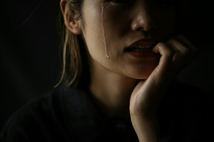 A woman cries with tears streaming down her face, symbolizing the emotional pain when a marriage was over.