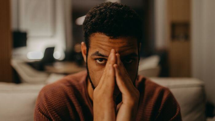 Man with hands clasped in front of face, distressed over unhinged therapist moments and recovery.