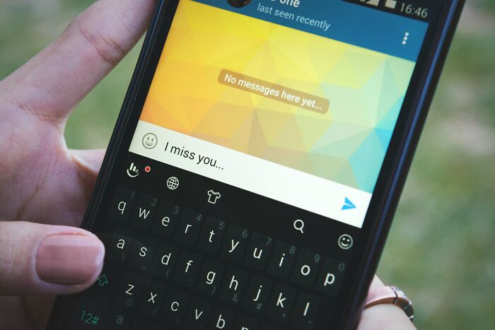 A person holding a phone with a message saying I miss you, showing a painful way men were made aware they were being cheated on.