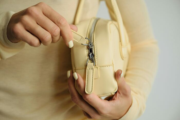 A person opening a bag, potentially revealing evidence of being cheated on.
