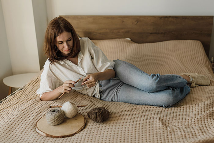 Woman knitting, finding peace to talk herself into breaking up with childish BF. Woman knitting, finding peace to talk herself into breaking up with childish BF.
