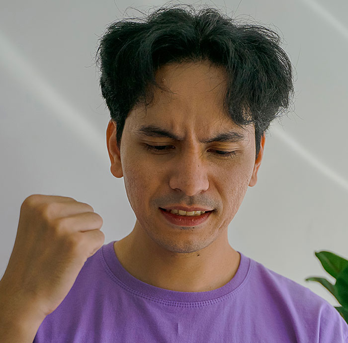 A man grimacing, looking frustrated. His friends helped him break up with his childish BF. A man grimacing, looking frustrated. His friends helped him break up with his childish BF.